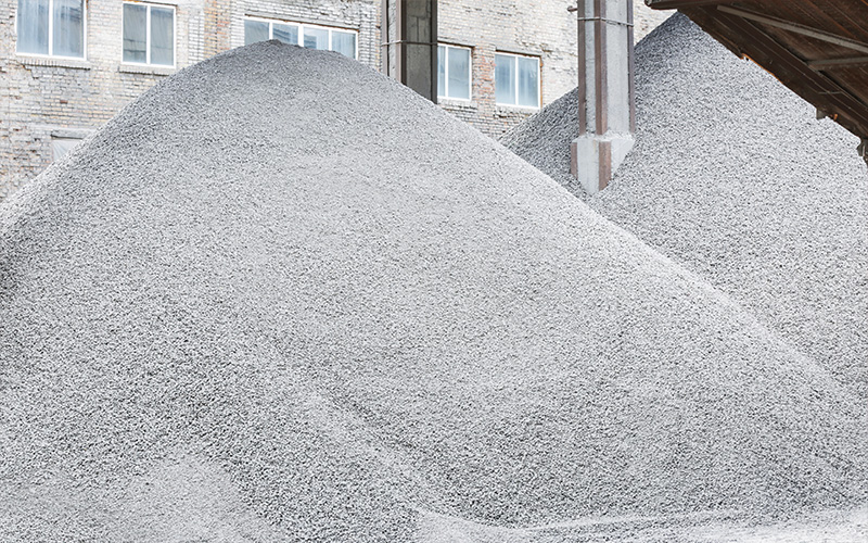 Massive piles of grey industrial construction sand and gravel.